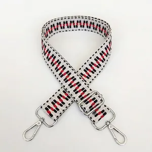 Detail view of woven bag strap with geometric patterns and silver swivel snap hooks