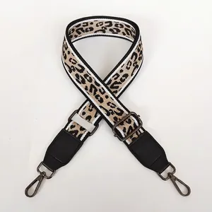 Detail of leopard print canvas strap with black leather trim and gunmetal swivel hooks