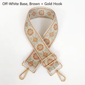 Détail de la bandoulière beige tissée avec broderie florale marron et mousquetons dorés