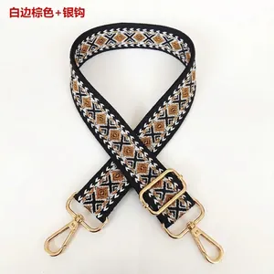 Detail view of woven diamond pattern bag strap with silver metal swivel hooks
