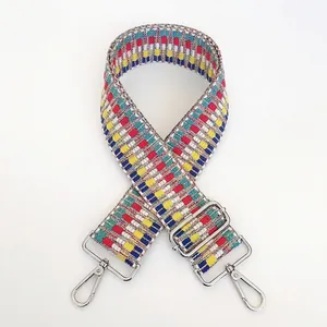 Close-up of colorful embroidered wide bag strap with silver metal hooks and buckle
