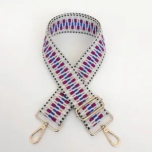Close-up of geometric pattern woven bag strap with golden metal adjustable buckles
