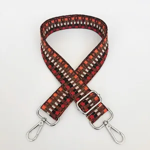 Detail of woven jacquard purse strap with geometric pattern and silver metal hooks