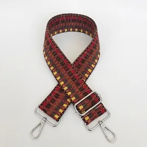 Detail view of woven geometric strap with silver metal swivel hooks and adjustable buckle