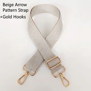 Close-up of beige herringbone woven bag strap with adjustable golden metal hooks