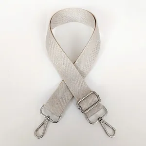 Close-up of beige herringbone replacement shoulder strap with silver metal swivel hooks