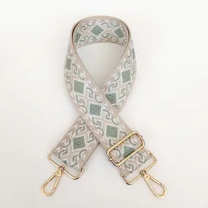 Detail of bohemian geometric woven bag strap with golden metal swivel hooks and buckles