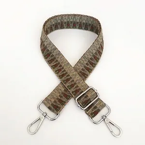Detail view of woven bohemian bag strap with colorful jacquard pattern and silver hooks