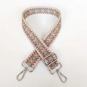 Close-up of pink and green geometric weave canvas bag strap with silver metal swivel hooks
