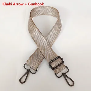 Detail of adjustable khaki woven crossbody strap with white arrow pattern and gunmetal hooks