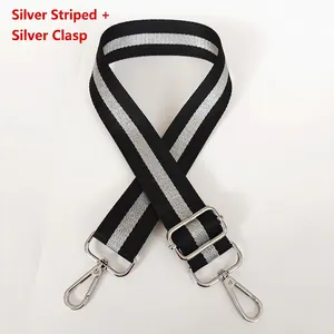 Detail of adjustable woven wide strap in black and striped silver with silver metal hook