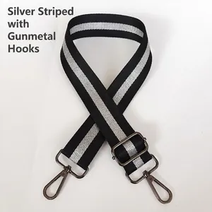Close-up of adjustable black and silver striped bag strap with gunmetal swivel hooks