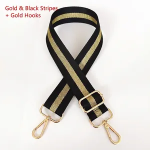Detail of adjustable black and gold striped wide crossbody bag strap with metal hooks
