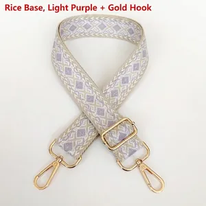 Close-up of beige and lavender geometric jacquard pattern webbing with gold metal hooks