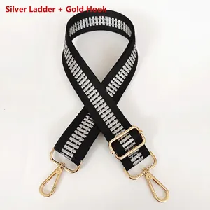 Detail of adjustable black nylon bag strap with silver ladder pattern and gold metal hooks