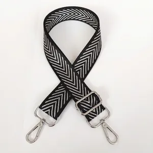 Detail of adjustable black and white chevron crossbody strap with silver metal hooks