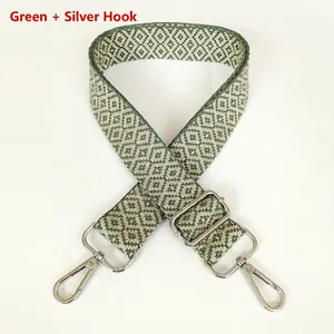 Detail of green diamond pattern woven bag strap with silver metal hooks and buckle