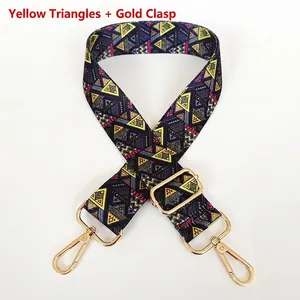Detail of adjustable wide shoulder strap with yellow geometric pattern and gold metal hooks
