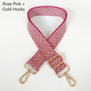 Detail of rose pink and beige geometric jacquard canvas bag strap with gold metal hooks