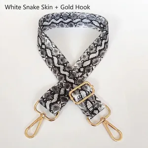 Detail of adjustable white snakeskin shoulder strap with elegant gold metal hooks