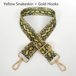Detail of adjustable yellow snake pattern bag strap with gold metal swivel hooks