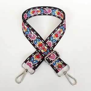 Detailed view of floral ethnic style wide bag strap with silver metal swivel hooks