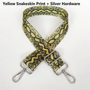 Detail of adjustable bag strap with yellow snake pattern and silver metal swivel hooks