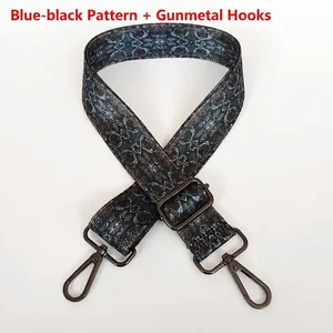 Detail of adjustable geometric strap with navy blue patterns and gunmetal swivel hooks