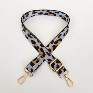 Détail de la bandoulière réglable à motif léopard avec mousquetons dorés