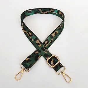 Détail de la bandoulière réglable à motif léopard vert avec crochets pivotants dorés