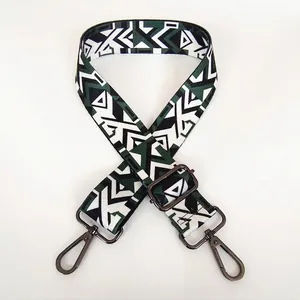 Detail of wide adjustable crossbody bag strap with green geometric camo and gunmetal hooks