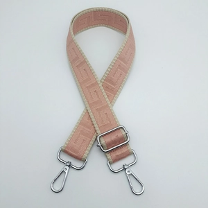 Adjustable pink and beige jacquard bag strap with silver swivel hooks and geometric pattern