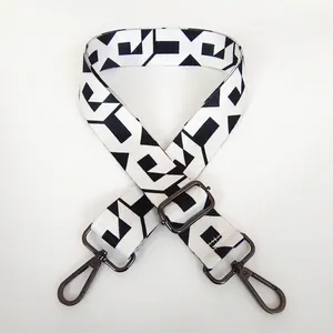 Macro detail of adjustable black and white geometric wide shoulder strap with metal hook