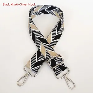Detail of adjustable woven canvas bag strap with silver metal lobster hooks and patterns