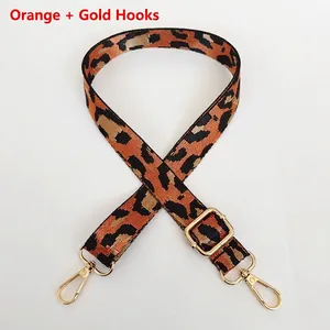 Détail d'une bandoulière réglable à motif léopard orange avec des crochets dorés