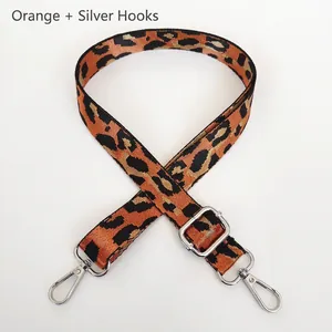Détail d'une bandoulière léopard réglable orange avec des crochets en métal argenté