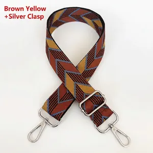 Close-up of thick canvas bag strap with colorful diamond pattern and silver metal hooks