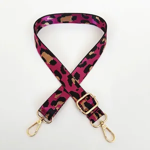 Vue détaillée d'une bandoulière léopard rose avec mousquetons et boucles en métal doré