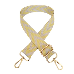 Adjustable wide woven shoulder strap with yellow and grey wavy pattern and gold metal hooks