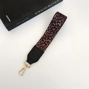 Détail de la dragonne léopard avec embout en cuir noir et crochet métallique doré