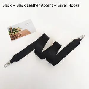 Detail of black fabric strap with leather ends and silver metal swivel hooks on white