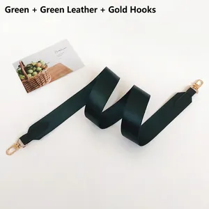 Detail of dark green fabric replacement bag strap with golden metal hooks and leather trim