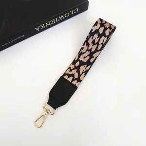 Détail de la dragonne à motif léopard avec fermoir doré et embout en cuir noir