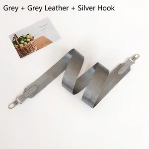 Detail of grey herringbone fabric strap with leather ends and silver metal hooks