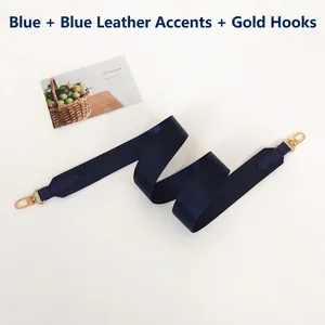 Detail of navy blue nylon woven bag strap with leather ends and golden metal hooks
