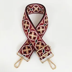 Detail of red and khaki geometric woven bag strap with golden metal swivel hooks