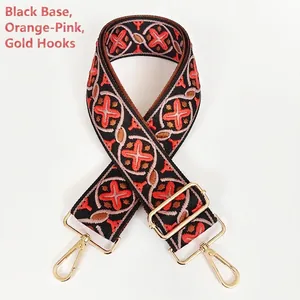 Close-up of ethnic jacquard purse strap in black and orange pink with gold hooks