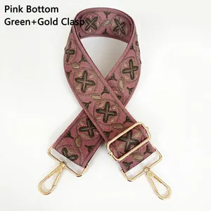 Detail of pink woven wide bag strap with green geometric pattern and gold lobster claws
