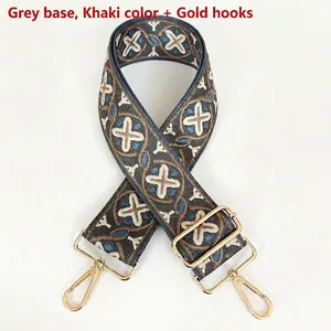 Close-up of grey wide woven bag strap with khaki blue geometric patterns and gold metal hooks