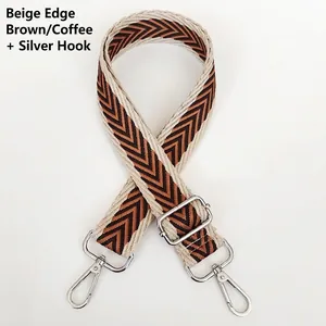 Close-up of adjustable woven purse strap with coffee brown V-pattern and silver hooks